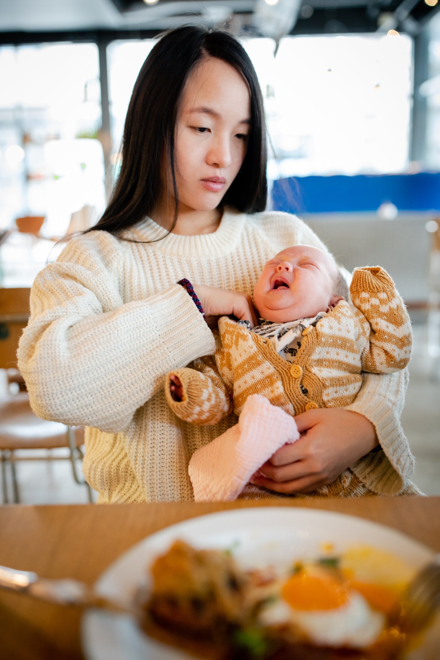 Mother holds her baby in a café | Photo: Getty Images 