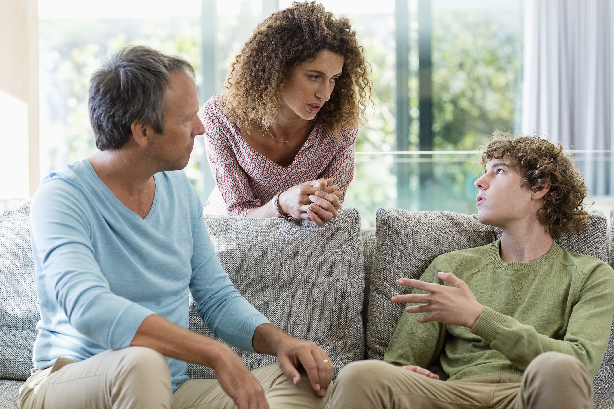 Parents talk to their teen son in the living room | Photo: Getty Images 