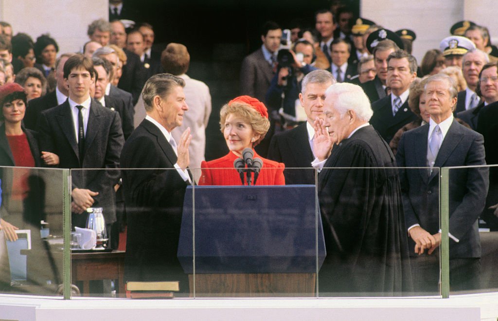 President-elect Ronald Reagan takes the oath of office during inauguration ceremonies in Washington, DC. His wife, Nancy, is holding the Bible and Chief Justice Warren Burger is administering the oath. | Source: Getty Images