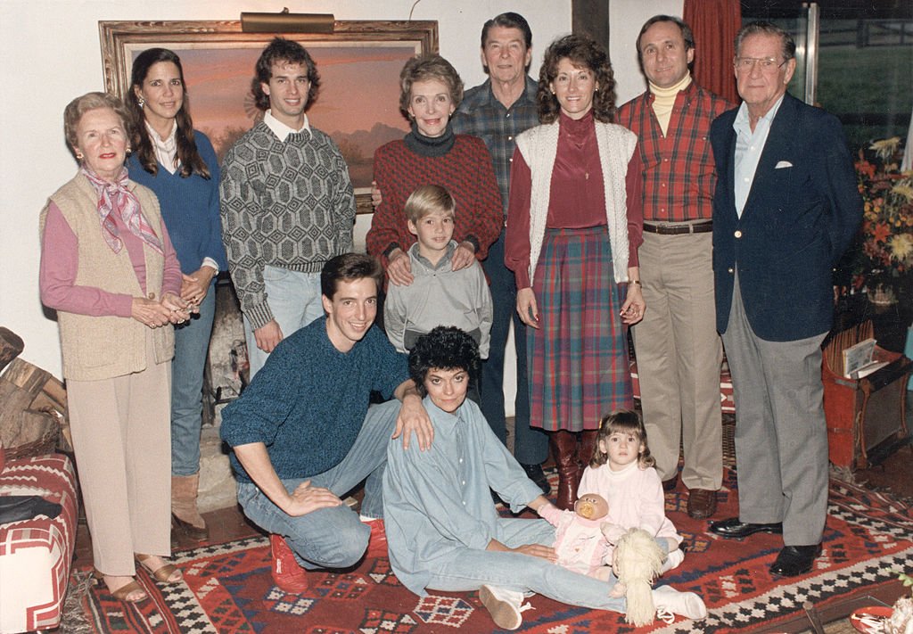 Portrait of President Ronald Reagan and First Lady Nancy Reagan with their family at Rancho del Cielo near Santa Barbara, California, November 28, 1985. Standing (L-R): Bess Reagan, Patti Davis, Paul Grilley, Cameron Reagan, Nancy Reagan, the President, Colleen and Michael Reagan, and Neil Reagan. Foreground, (L-R): Ron, Doria, and Ashley Marie Reagan. | Source: Getty Images
