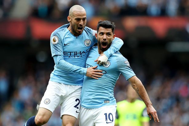 Sergio Aguero of Manchester City celebrates with teamate David Silva after scoring his team's first goal during the Premier League match between Manchester City and Huddersfield Town at Etihad Stadium on August 19, 2018 in Manchester, United Kingdom.