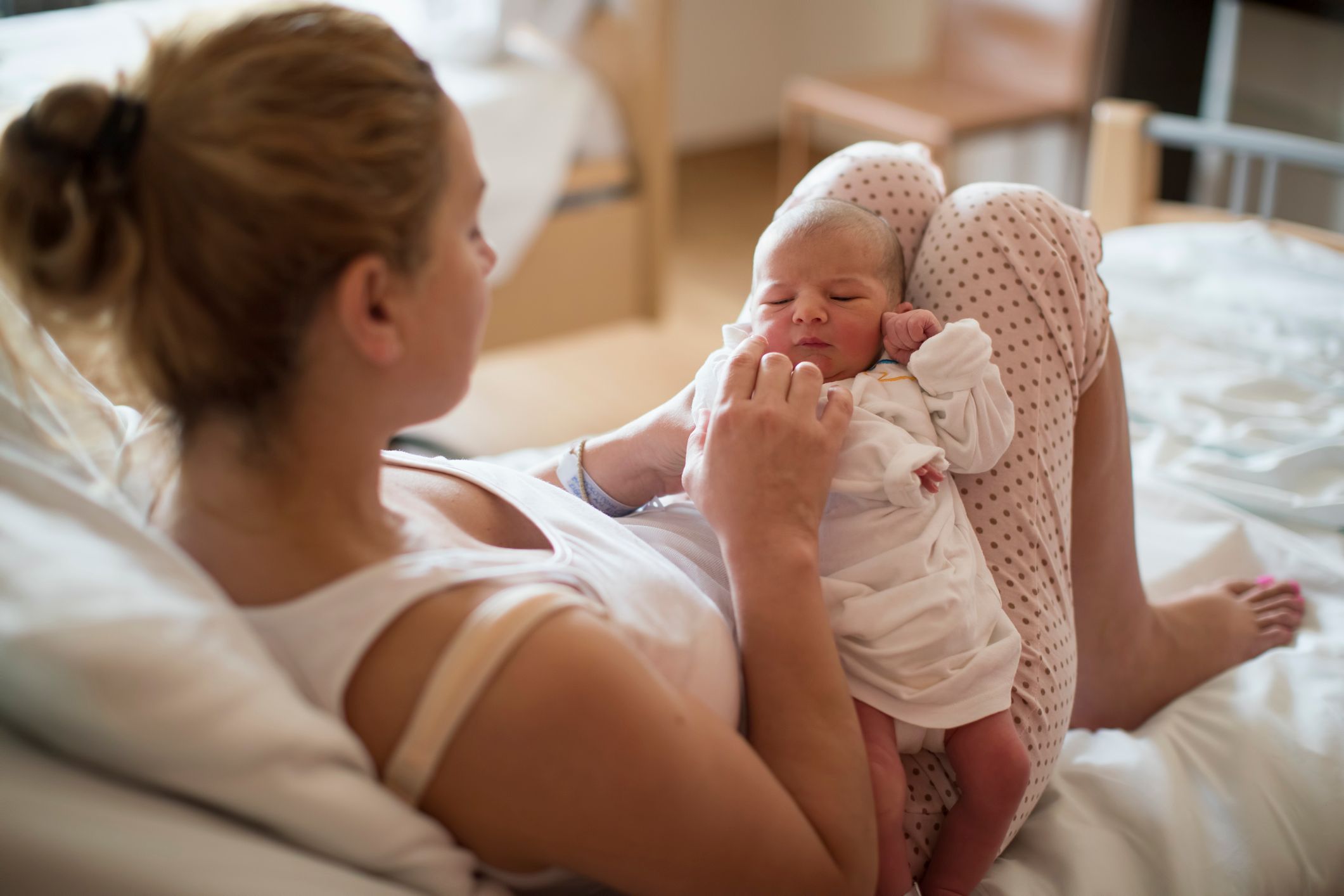 A mom holding her newborn baby in a room. | Source: Shutterstock