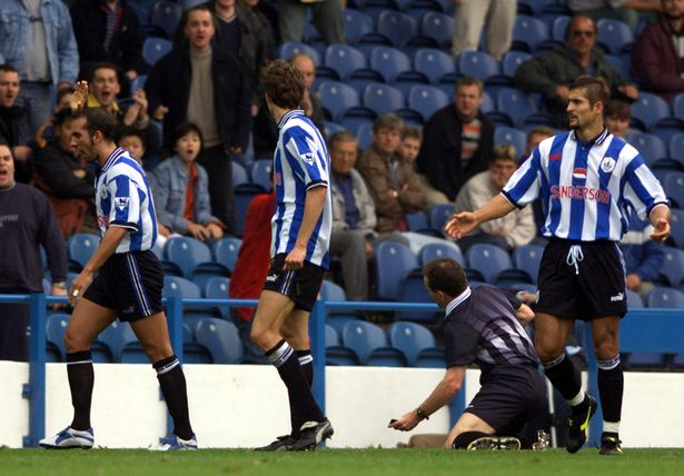 Paolo Di Canio marches away after shoving Paul Alcock to the ground 13 years ago today
