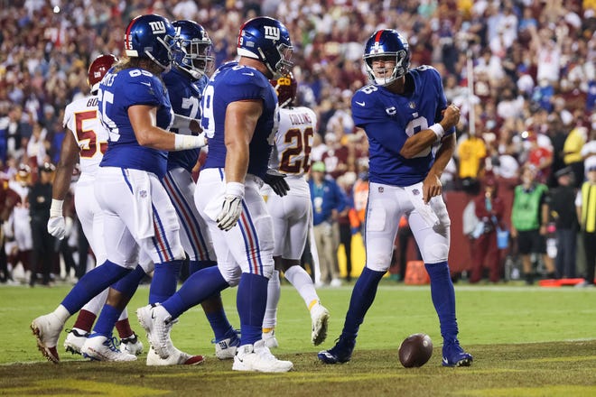 Daniel Jones of the New York Giants celebrates with teammates after rushing for a touchdown during the first quarter against the Washington Football Team at FedExField on September 16, 2021 in Landover, Maryland.