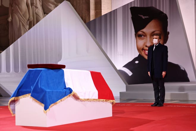 French President Emmanuel Macron pay respect to the cenotaph of Josephine Baker, covered with the French flag, at the Pantheon in Paris, France, Tuesday, Nov. 30, 2021, where she is symbolically inducted, becoming the first Black woman to receive France's highest honor. Her body will stay in Monaco at the request of her family.
