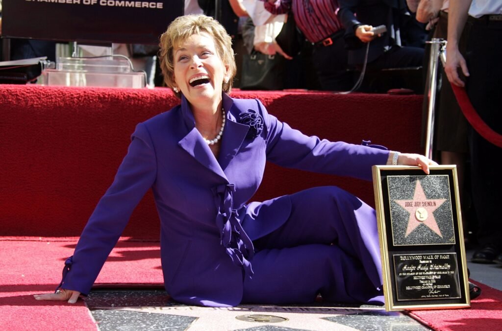 Judge Judy posing with her star on the Hollywood Walk of Fame