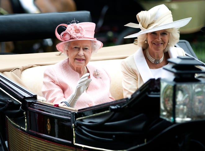 Queen Elizabeth II waves to the crowds with Camilla, Duchess of Cornwall as they arrive by carriage on the first day of the Royal Ascot horse race meeting in Ascot, June 18, 2013.