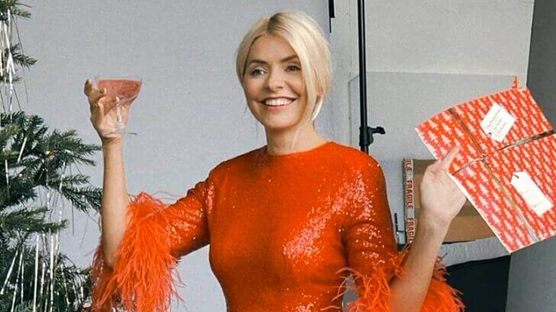 Holly Willoughby has a Christmas Makeover: She shows off her tanned legs with a red minidress that sparkles in the sunlight.