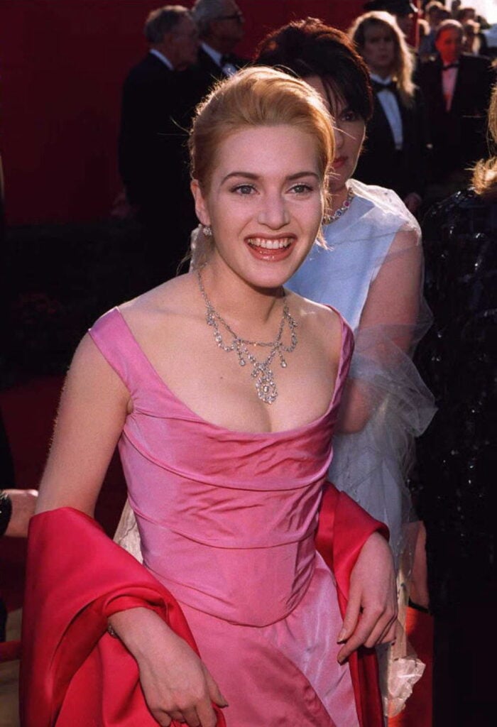 Kate Winslet smiles in pink gown with dark pink wrap